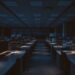 Empty crypto exchange office desks with market chart monitors representing Coinbase restructuring